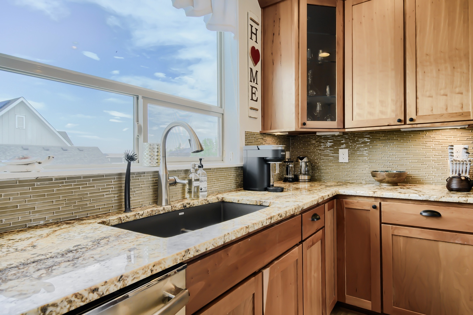 Prepare your favorite meals in this well-appointed kitchen while gazing out at beautiful waterfront views through the expansive windows. Warm wood cabinetry and granite countertops create a welcoming space for cooking and gathering.