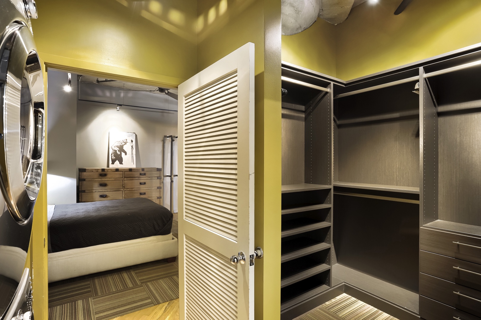 Your spacious walk-in closet with custom shelving and hanging space connects seamlessly to your bedroom, offering abundant storage for all your belongings during your stay.