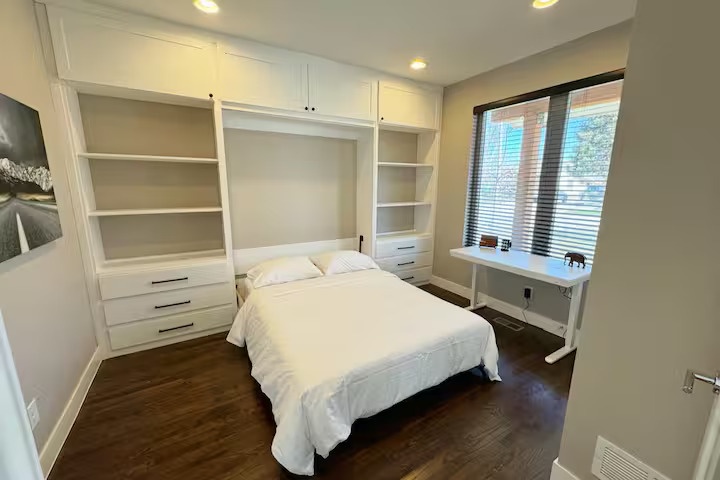 Your Murphy bed maximizes space while providing comfort, surrounded by built-in storage and a peaceful window view.