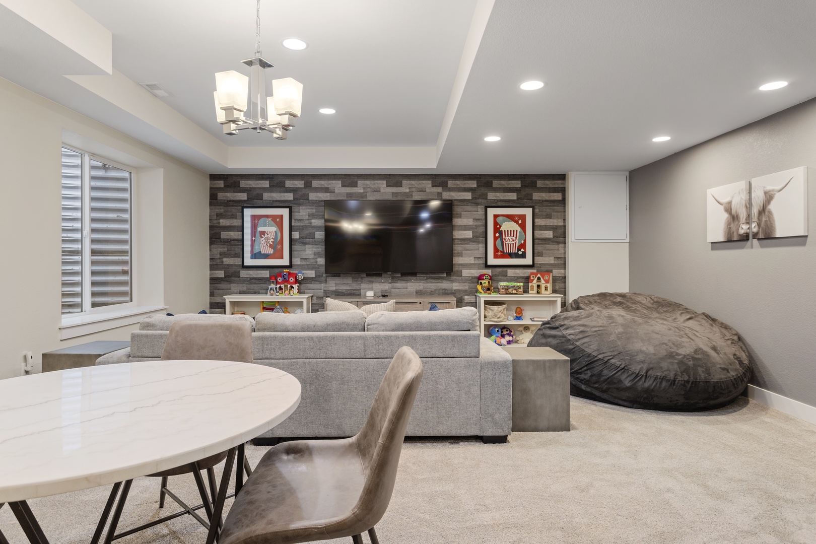 Sink into the plush sectional or giant bean bag in your entertainment space, where movie nights feel extra cozy under modern lighting.