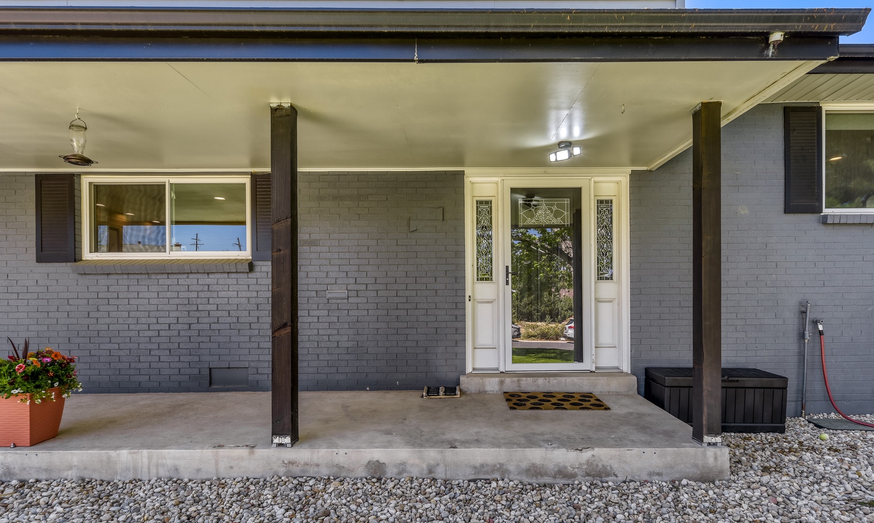 The property's welcoming front entrance features a covered porch with decorative glass sidelights and a well-maintained mid-century exterior.