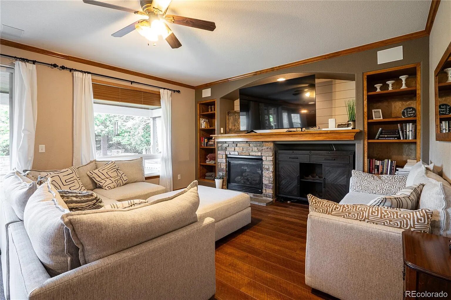 Unwind in your cozy living room with stone fireplace, built-in shelves, and comfortable seating perfect for relaxing evenings together.