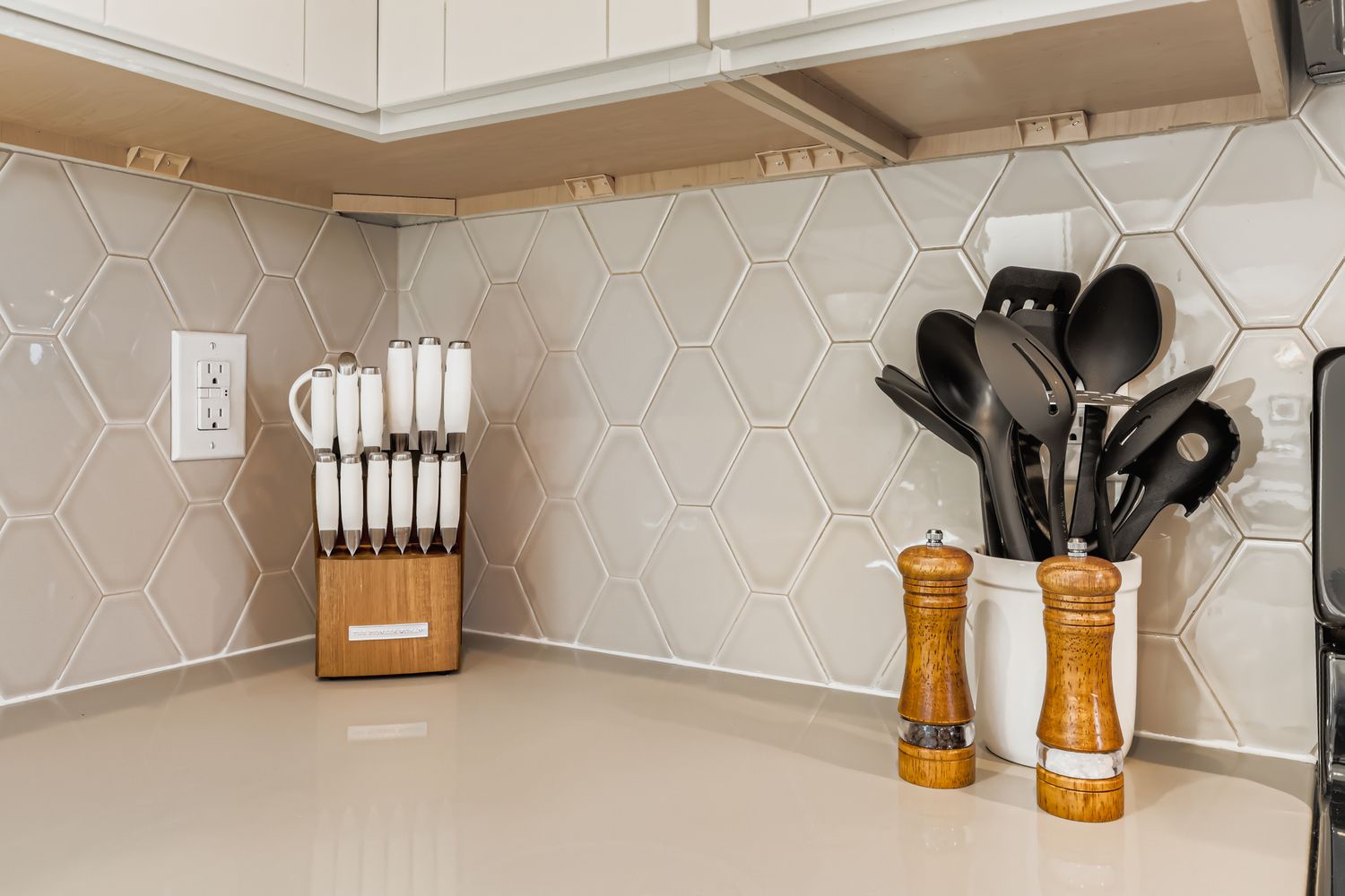 Your fully equipped kitchen counter features modern hexagonal tile backsplash, quality knife set, and everything you need to prepare home-cooked meals during your stay.