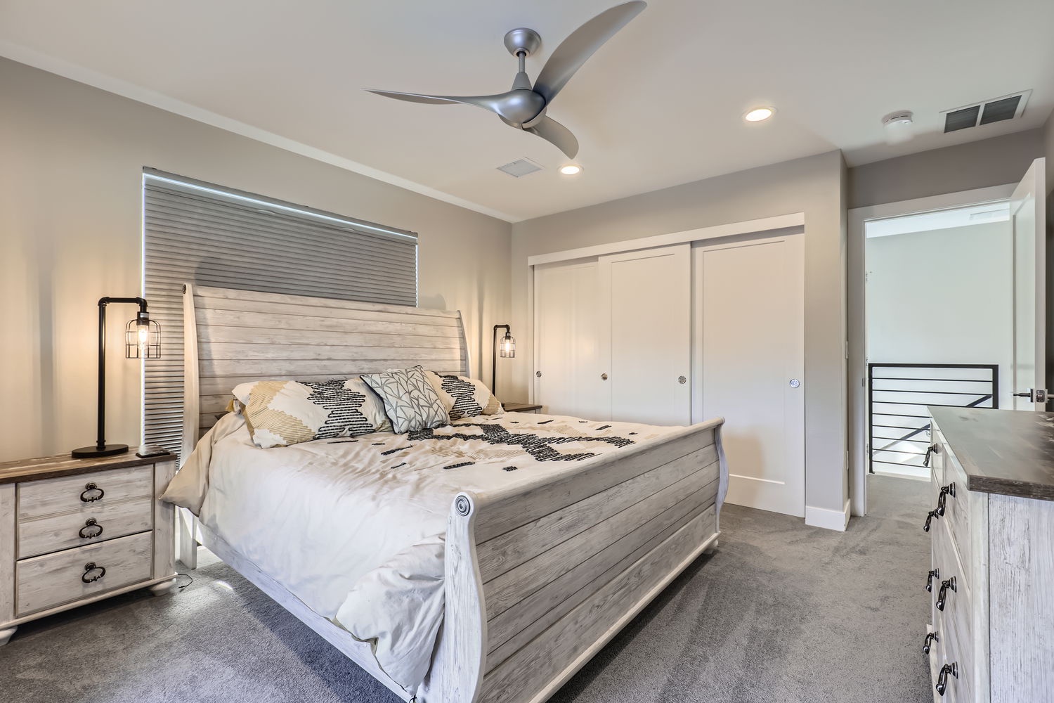 Slip into your serene retreat with a plush bed, soft lighting, and breezy ceiling fan overhead. The clean lines, ample closet space, and natural light create the perfect nest for your restful nights.