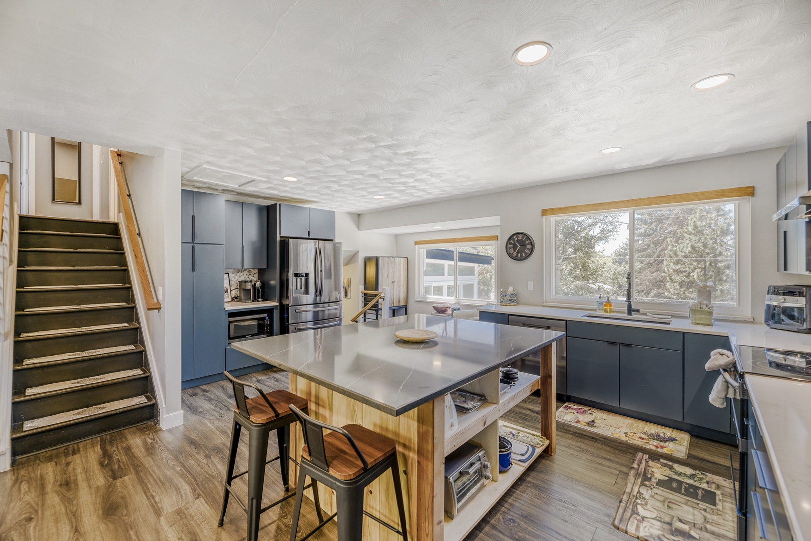 Your spacious, modern kitchen features sleek cabinetry, stainless steel appliances, and a large island perfect for meal prep or casual dining together.