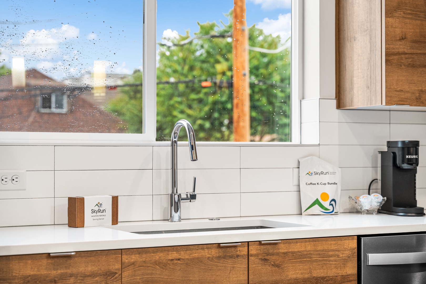 Your modern kitchen features sleek white countertops, warm wood cabinets, and a fully-stocked coffee station so you can start each morning just right.