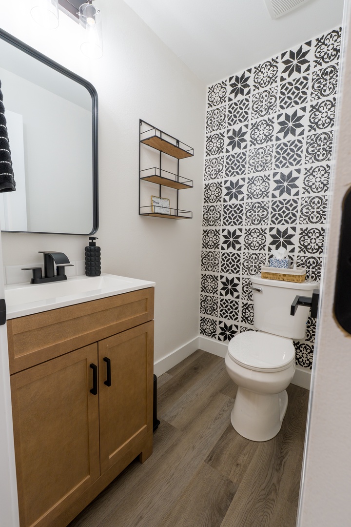 Your stylish powder room features striking patterned tiles, warm wood vanity, and thoughtful storage details for your comfort.
