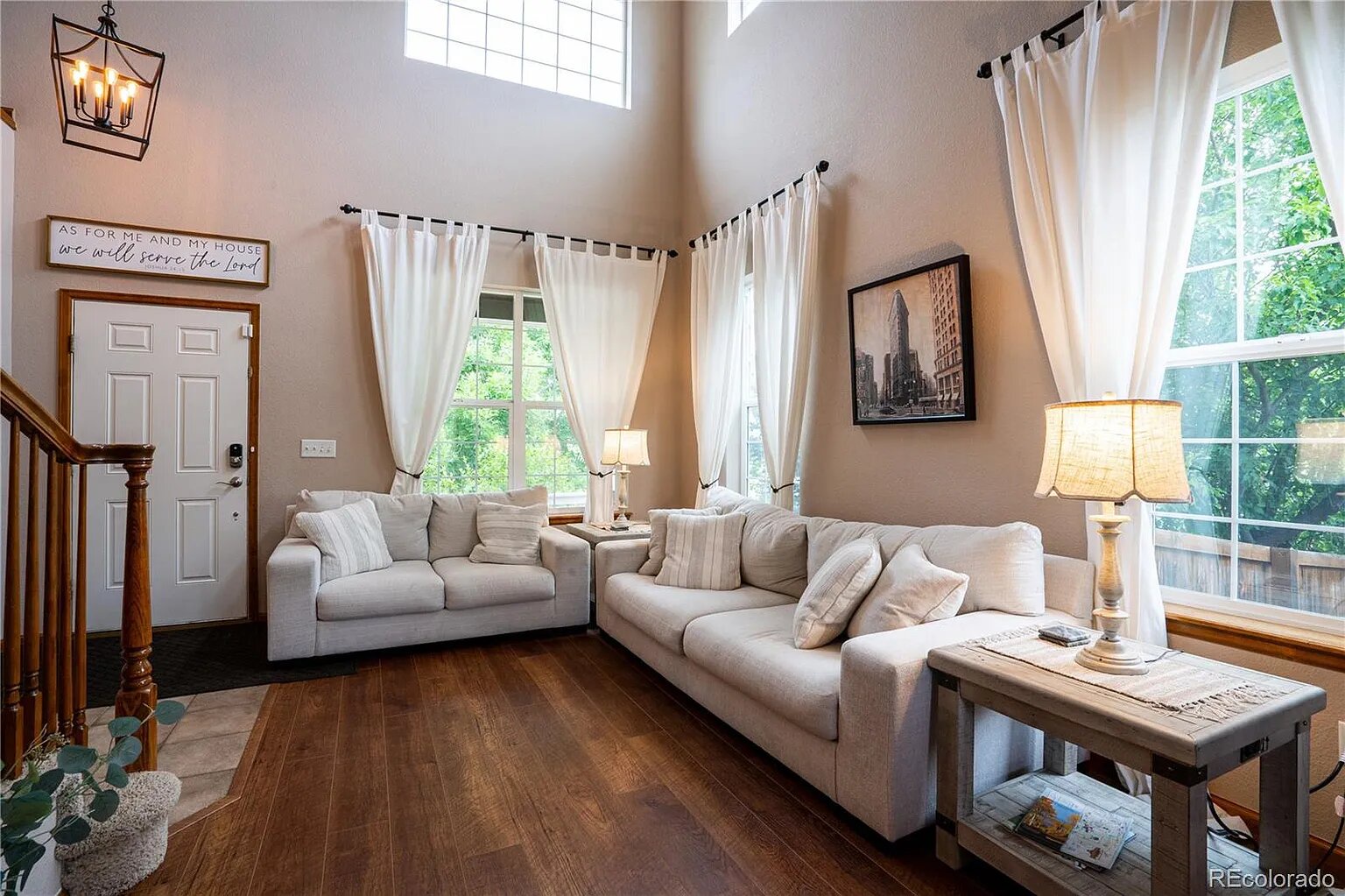 Sink into this plush sectional sofa where natural light streams through floor-to-ceiling windows, creating your perfect retreat for morning coffee or evening relaxation.