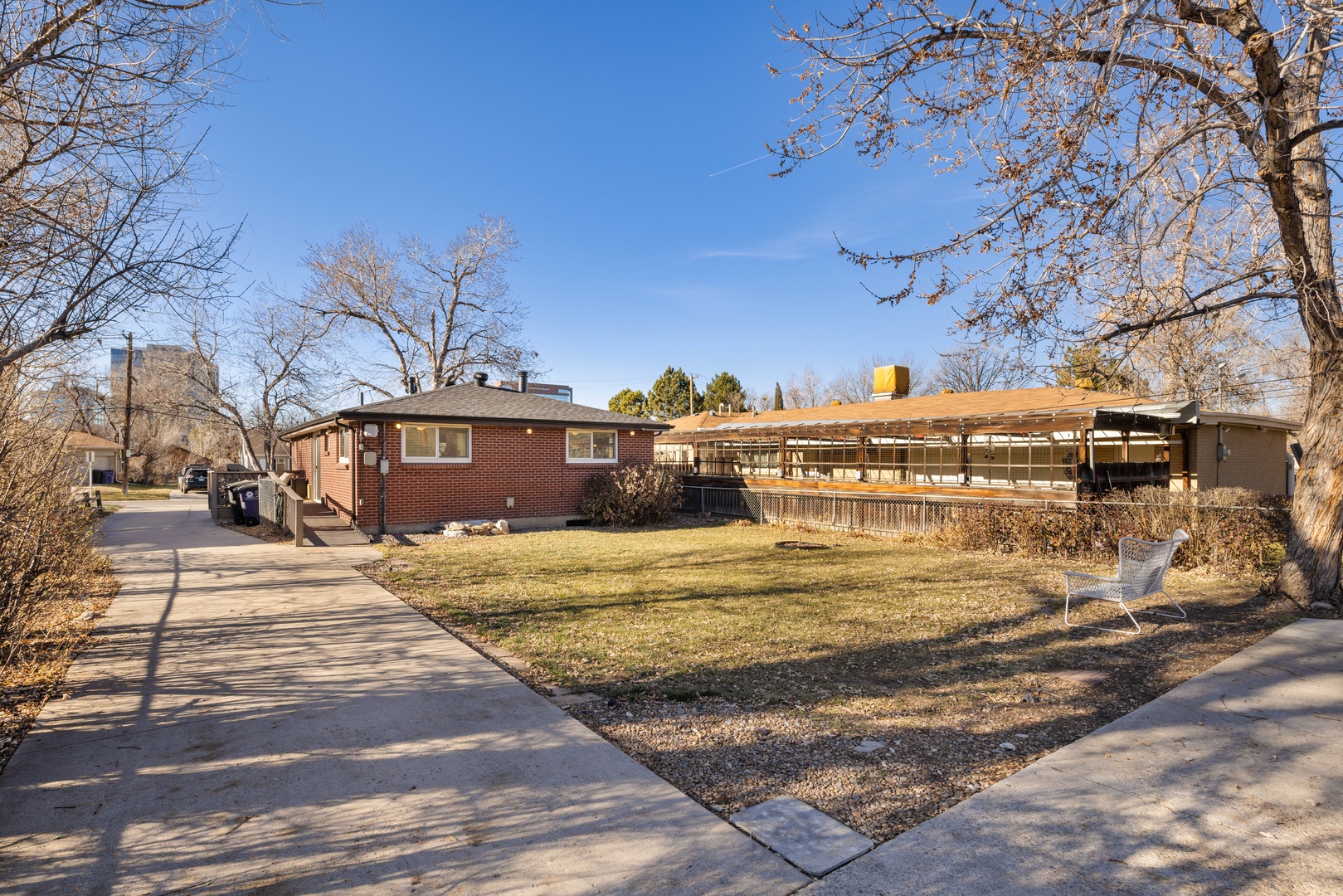 A charming brick home sits in a peaceful residential neighborhood with mature trees and well-maintained grounds.