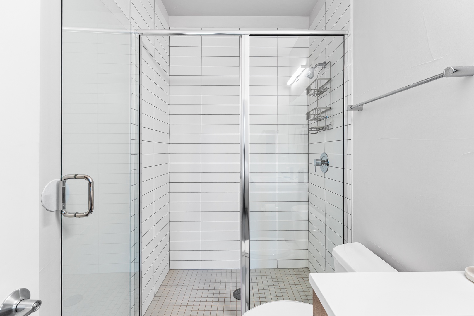 Step into your sleek, bright bathroom with a spacious walk-in shower and modern white tile. Fresh, clean, and ready for your morning routine or a relaxing evening rinse.
