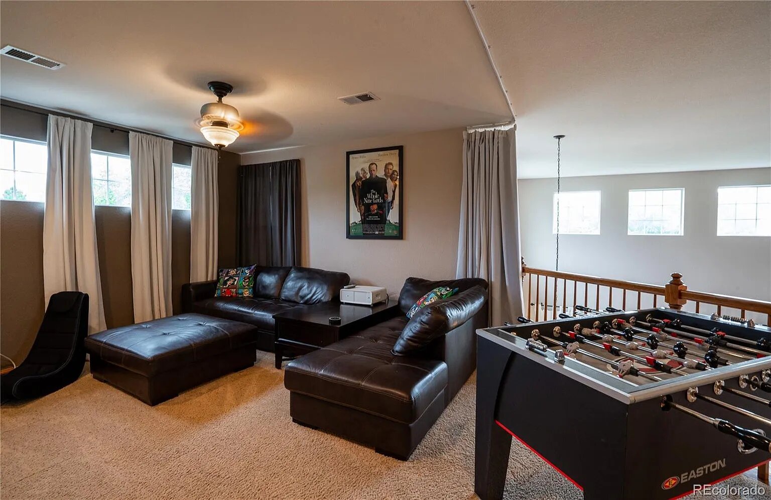 Unwind in your private game room featuring plush leather seating and foosball table - perfect for memorable evenings with friends and family.