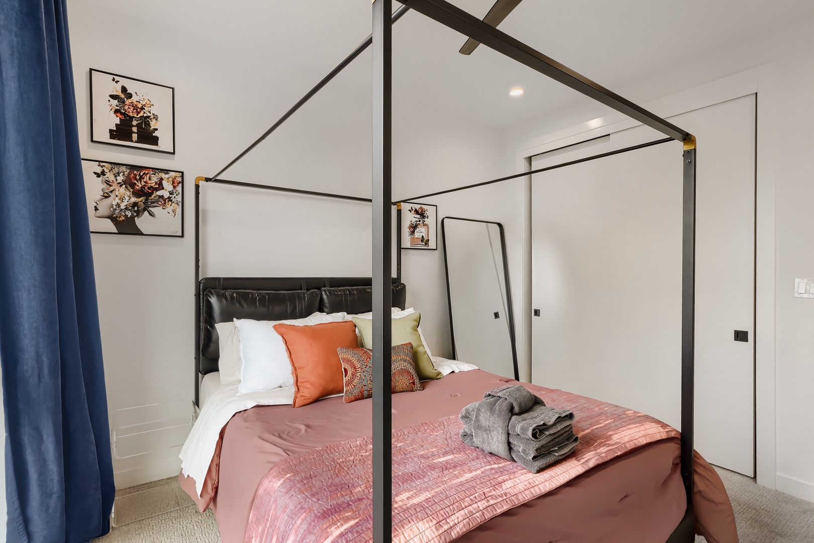 Sink into your elegant canopy bed, styled with soft linens and rich coral accents—your restful retreat awaits after a day of exploring.