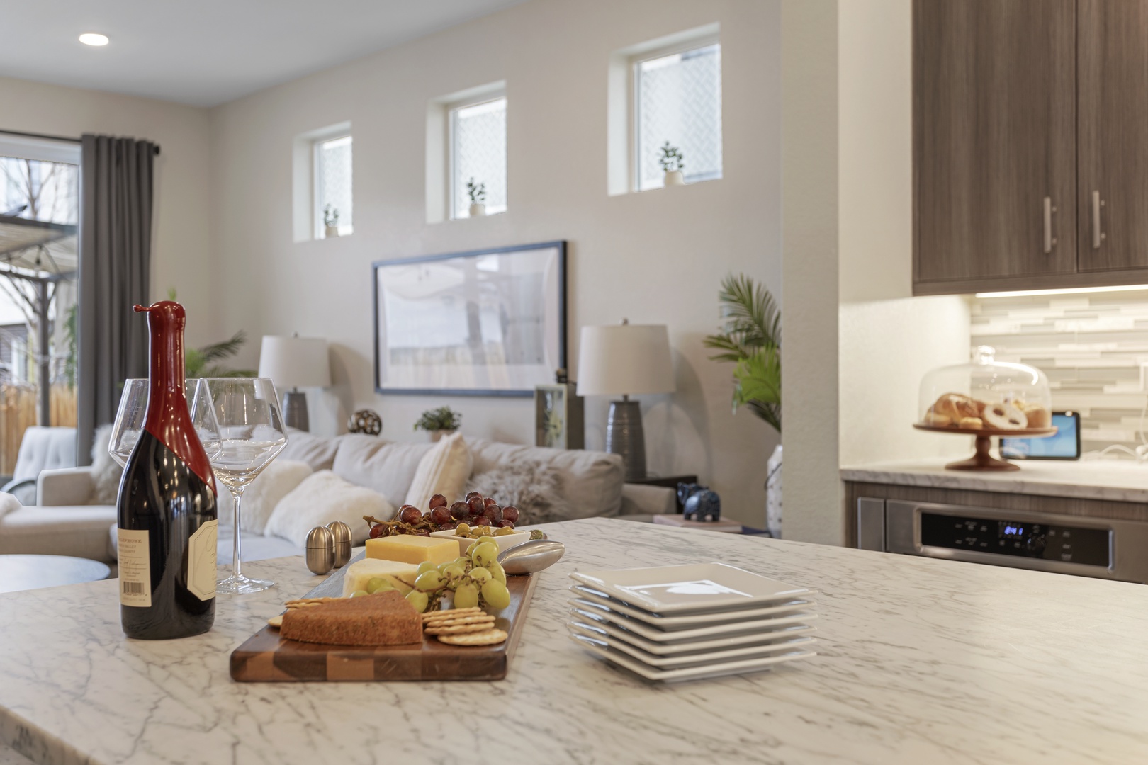Your modern kitchen flows beautifully into the living space, perfect for preparing cheese boards while staying connected with guests.