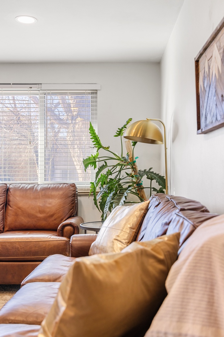 Sink into plush leather seating where natural light streams through your windows, creating the perfect spot to unwind with morning coffee or evening relaxation.