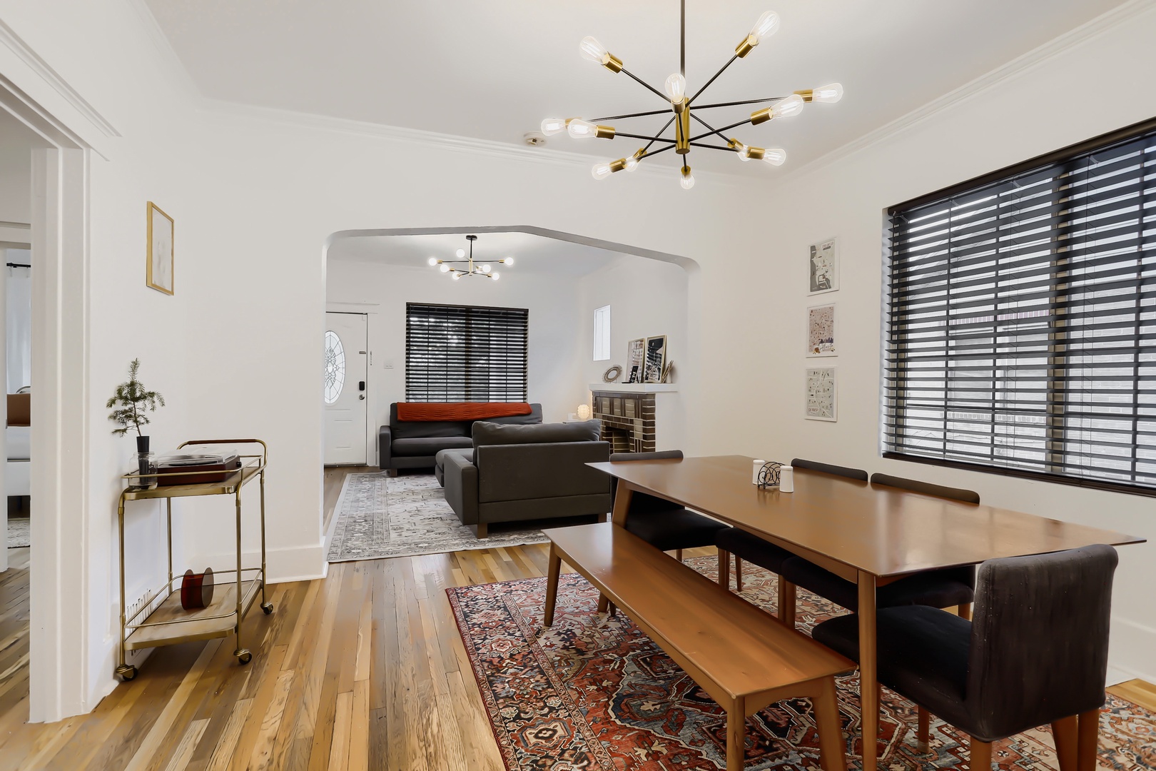 Step into your bright, open living and dining space where warm wood floors, stylish modern fixtures, and abundant natural light create the perfect setting for relaxing meals and comfortable evenings.