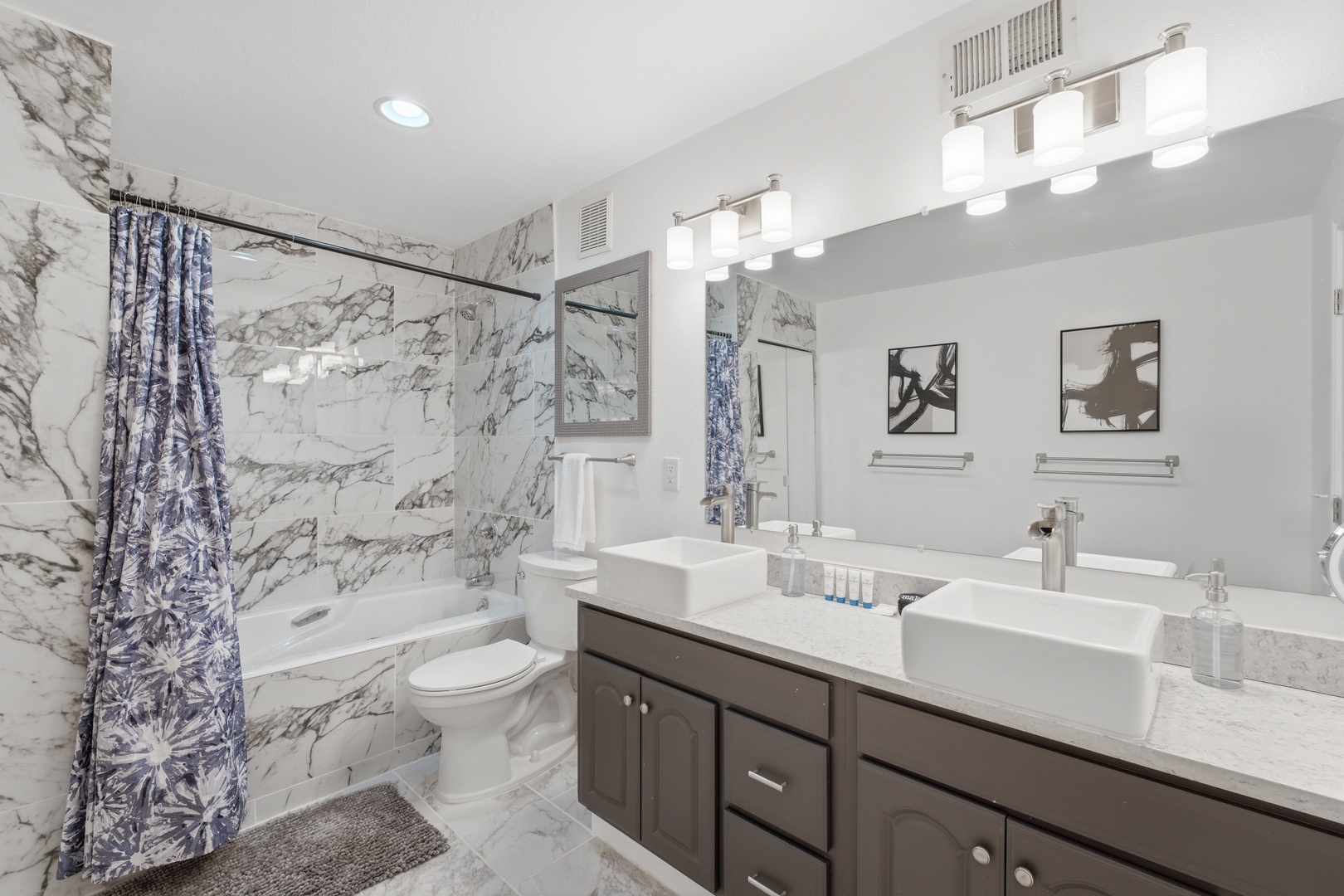 Refresh in your elegant marble bathroom featuring dual sinks, a soaking tub, and modern fixtures—perfect for unwinding after your adventures.