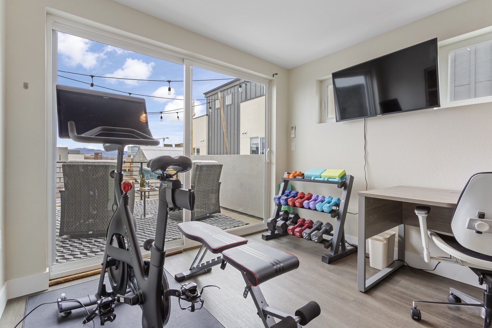 Your private fitness sanctuary awaits with cardio equipment, weights, and natural light streaming through large windows.