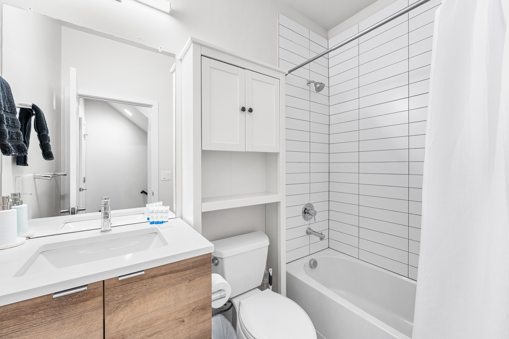 Step into your bright, modern bathroom featuring crisp subway tile, a full tub-shower combo, and stylish wood-tone vanity. Everything you need to unwind after a day exploring.