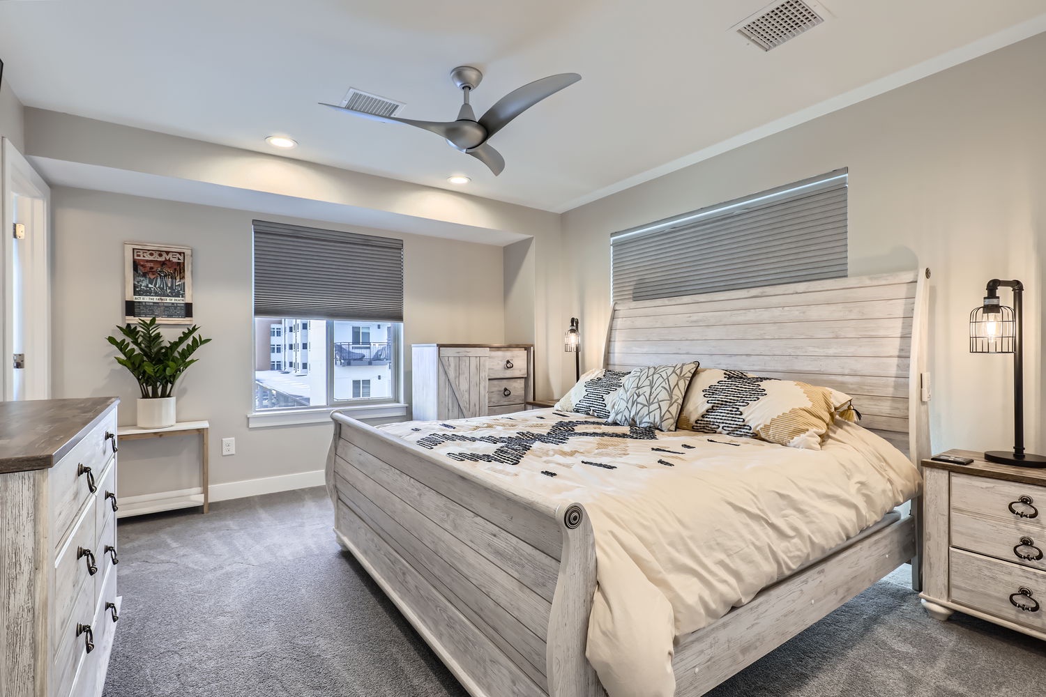 Your peaceful bedroom retreat features a plush bed beneath a ceiling fan, perfect for restful nights in comfort and style.