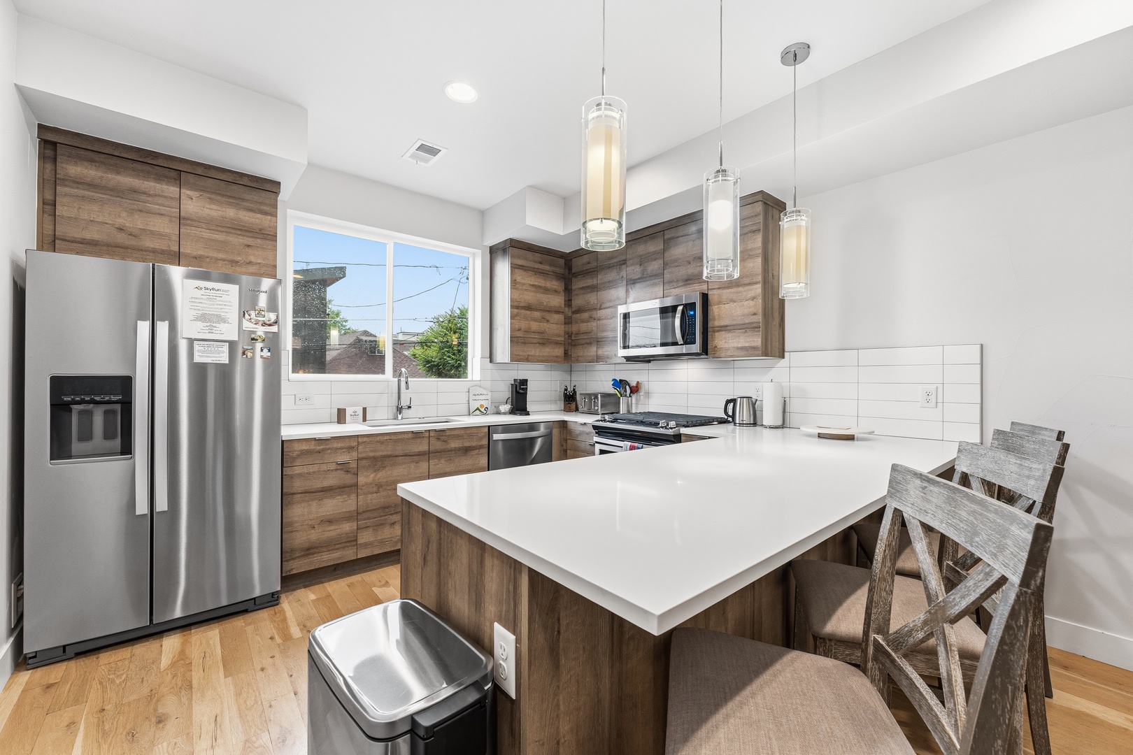 Your fully equipped kitchen features sleek quartz countertops, warm wood cabinetry, and modern stainless steel appliances—perfect for preparing meals together during your stay.
