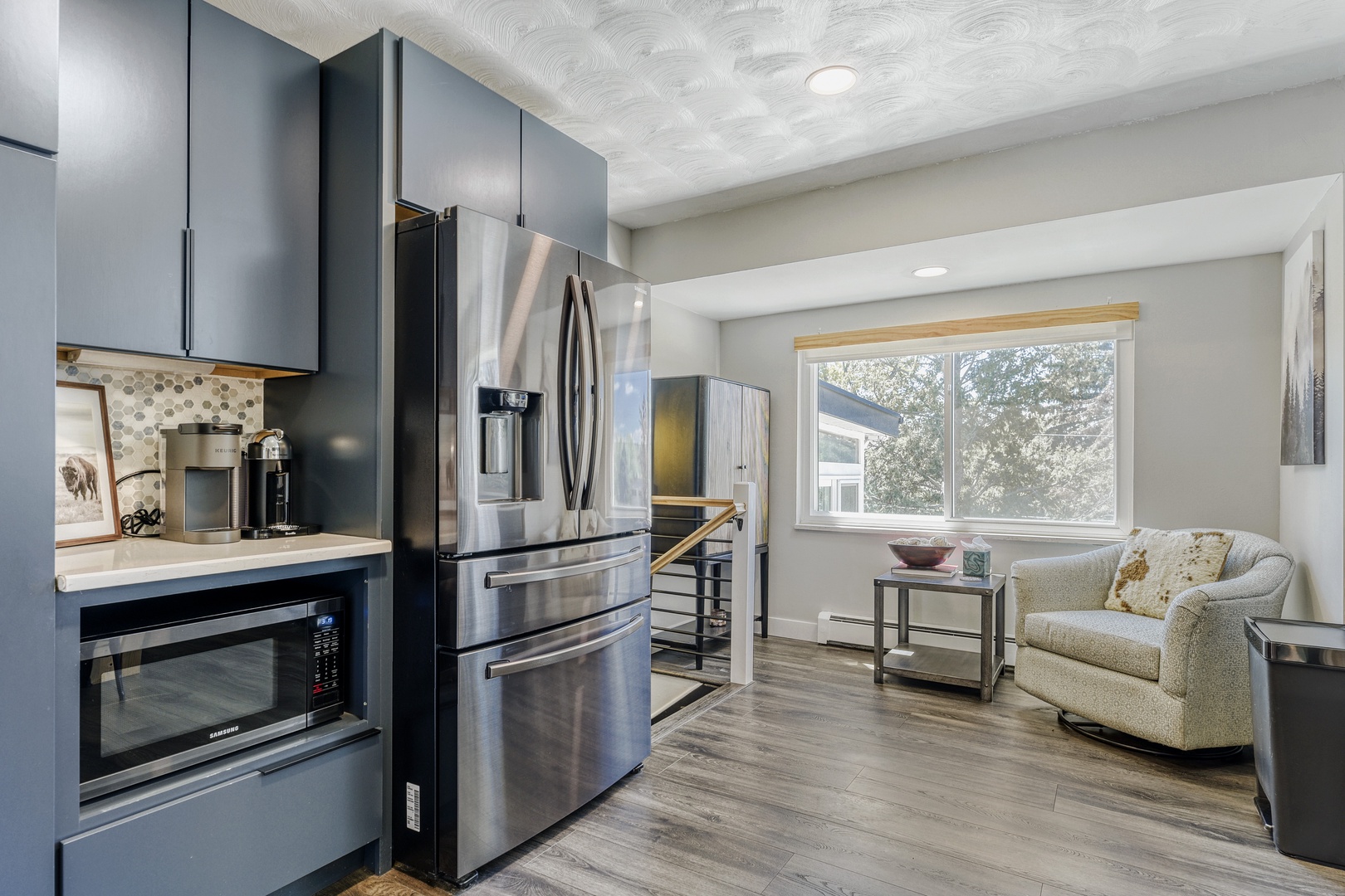 Your modern kitchen features sleek stainless steel appliances and flows seamlessly into a bright living area with cozy seating, perfect for unwinding after exploring the area.