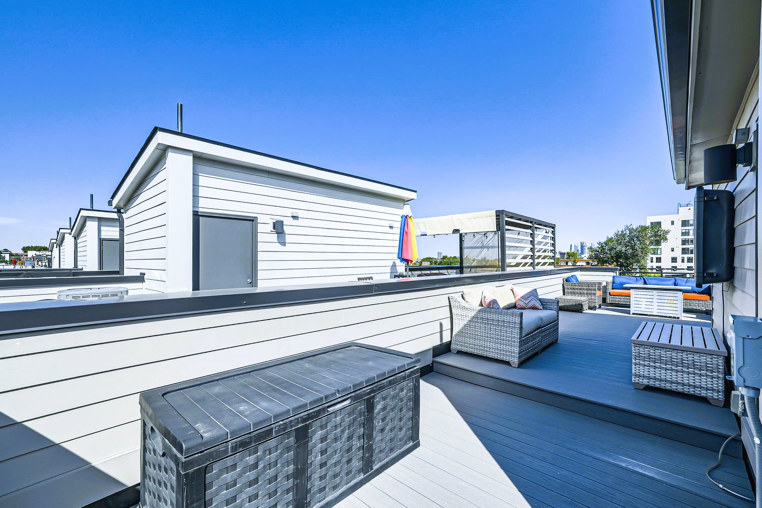 Your private rooftop terrace offers comfortable seating and panoramic city views under clear blue skies.