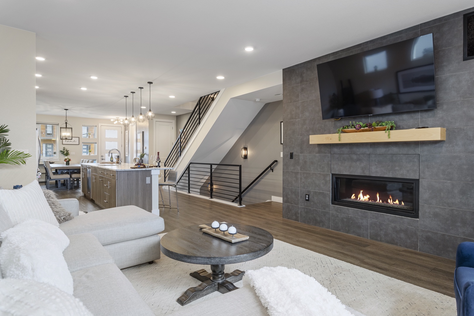 Unwind by your stunning fireplace in this open living space with modern kitchen and sofa.