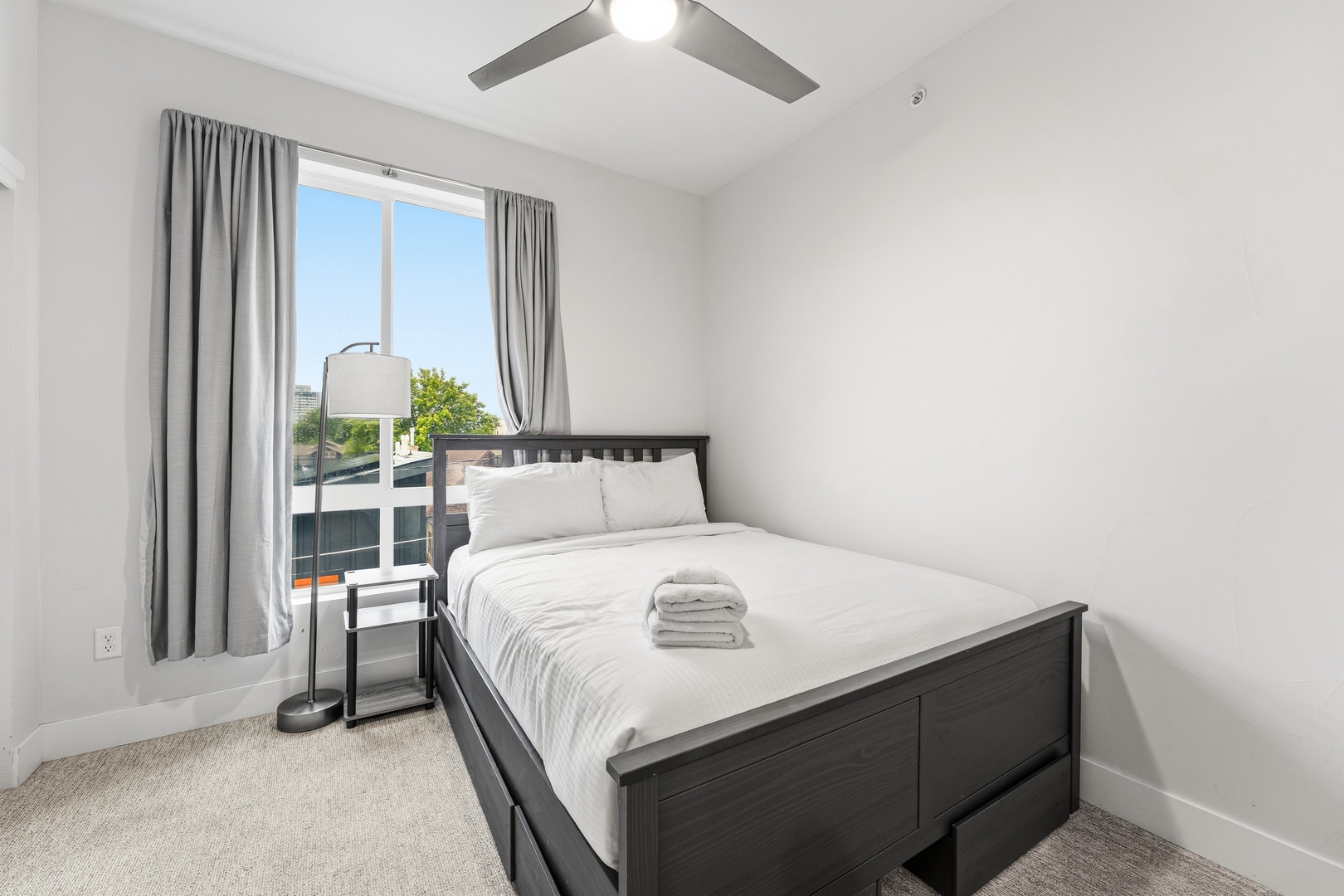 Sink into crisp linens in your private bedroom, where a gentle ceiling fan and natural light create the perfect sanctuary for restful nights.