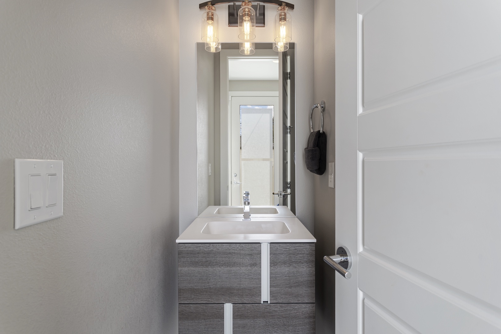 Step into your sleek powder room, where warm lighting and modern fixtures create the perfect space to freshen up.