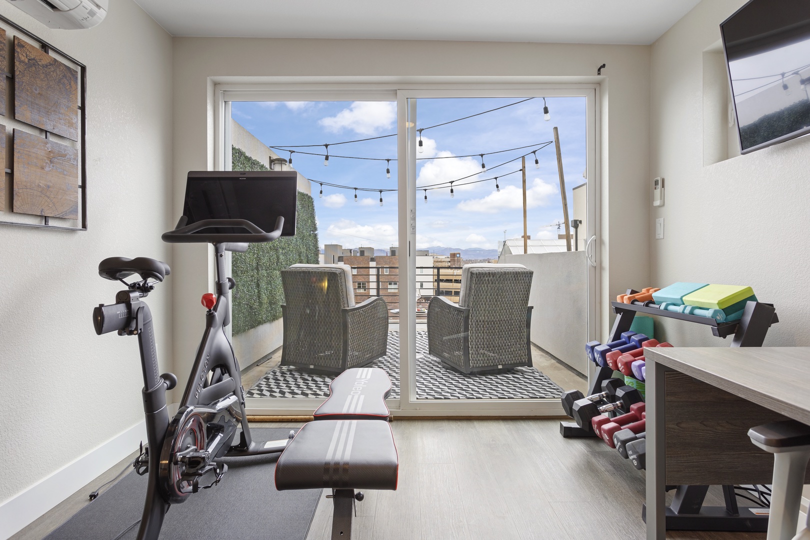 Your private fitness space opens to a stunning balcony, where colorful resistance bands await your workout with city views.