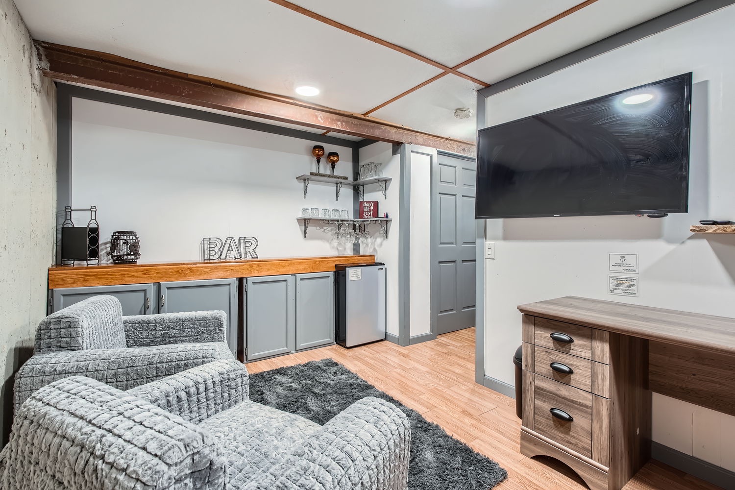 Your private lounge space with a stylish bar setup, perfect for unwinding with a favorite drink. Cozy seating invites relaxation, while the modern TV and warm wood accents create a welcoming retreat.