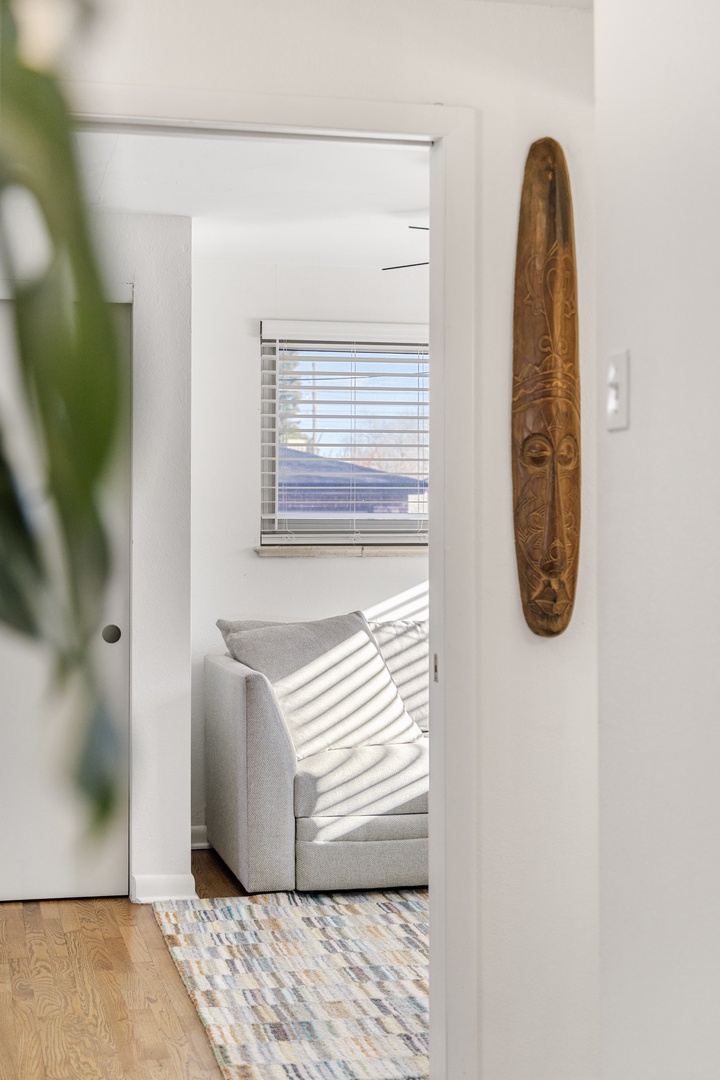 Step into your bright, thoughtfully decorated space where natural light creates beautiful shadow patterns across comfortable furnishings.