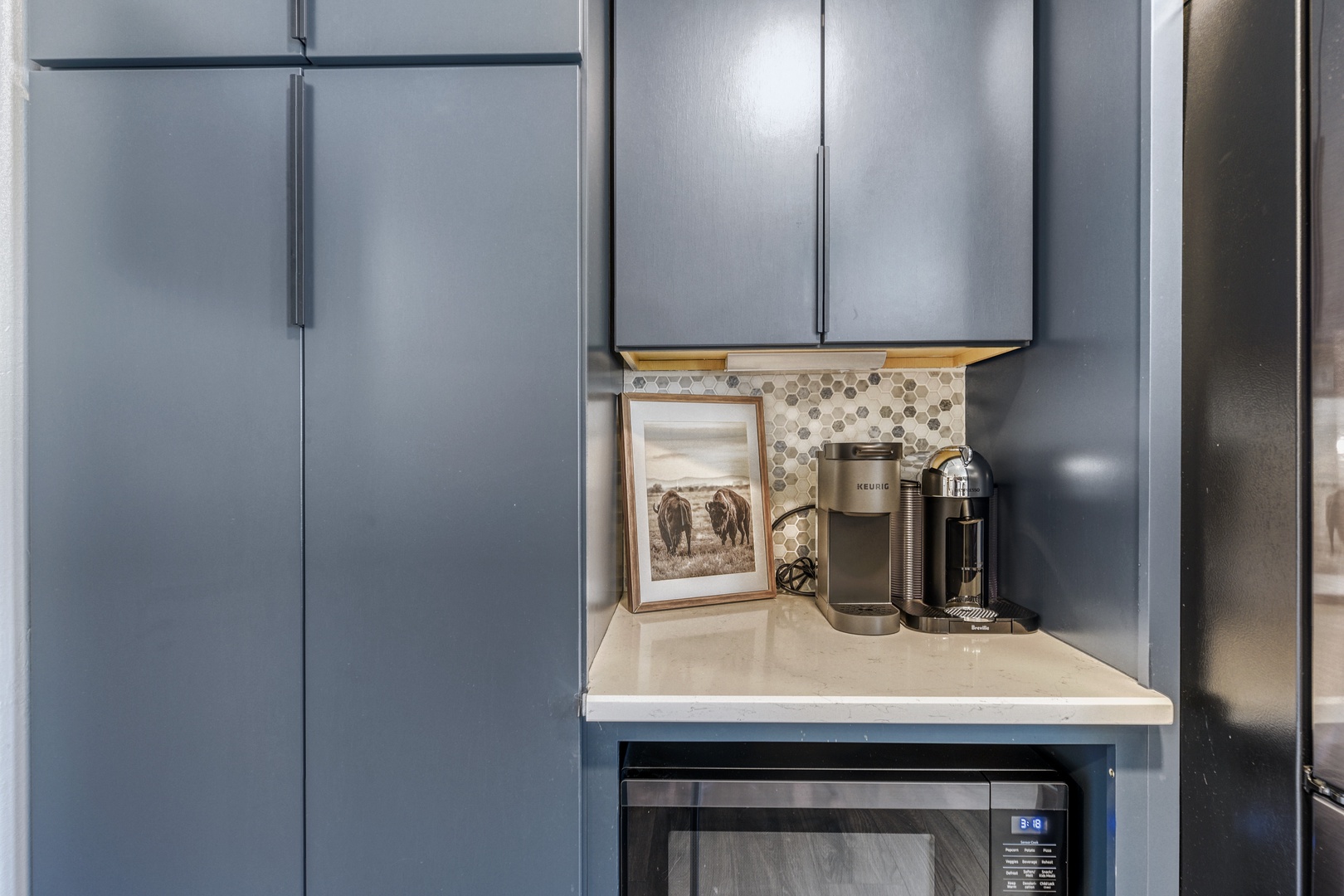 Your modern kitchen features sleek stainless appliances, stylish backsplash, and a Keurig coffee station—everything you need for easy meal prep and morning brews.
