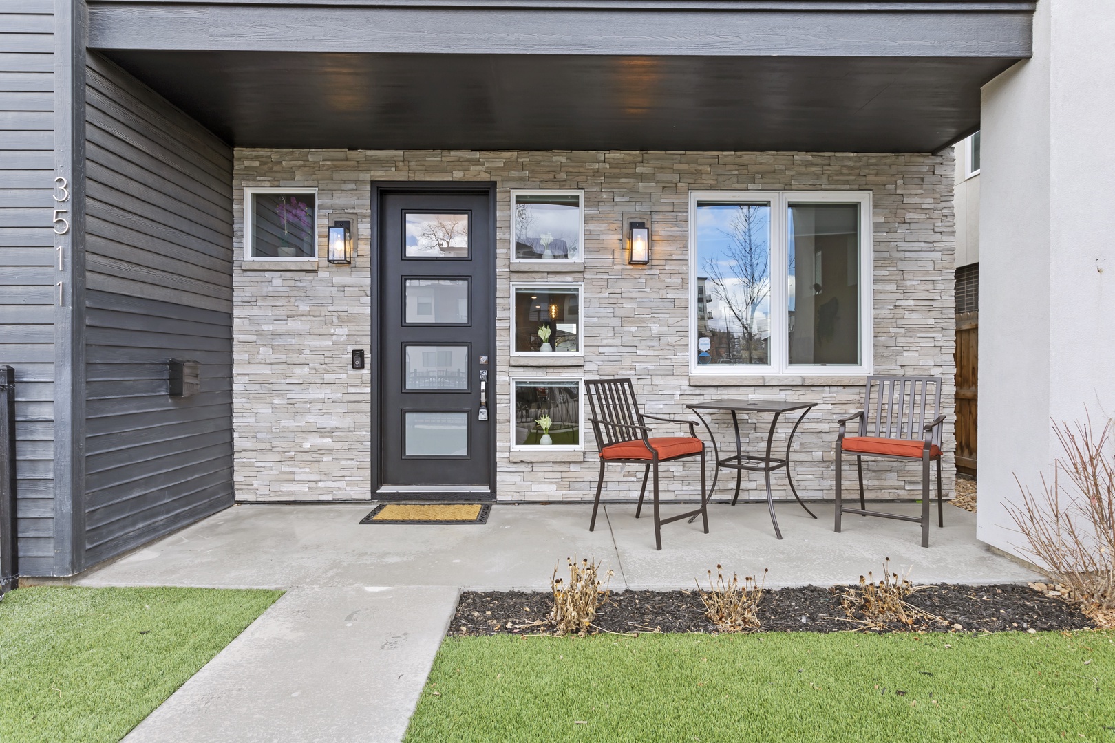 Modern entrance with stylish stone accents and a private covered porch for your morning coffee or evening relaxation.
