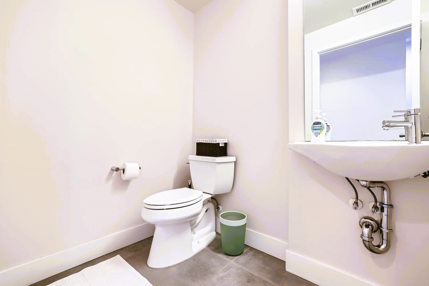 Step into your pristine powder room with modern fixtures and natural light streaming through the window for your comfort.