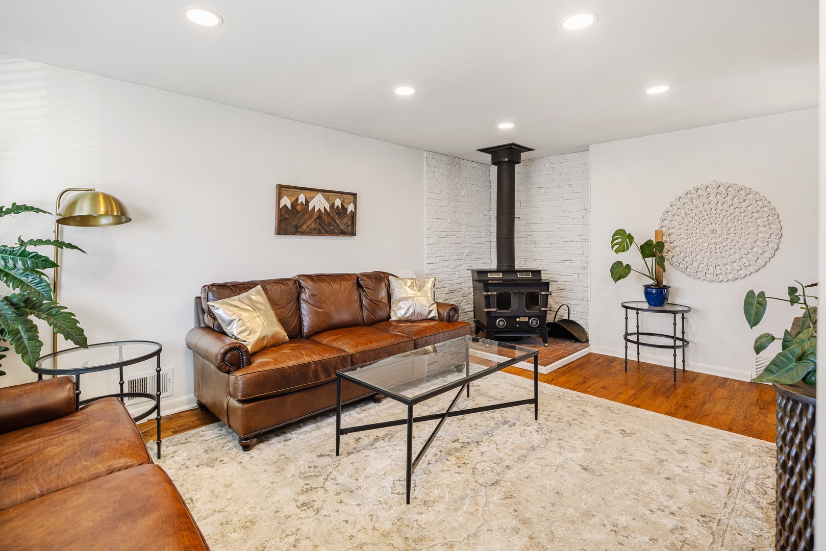 Cozy up by the wood-burning fireplace in this stylish living room with rich leather seating and modern mountain decor.