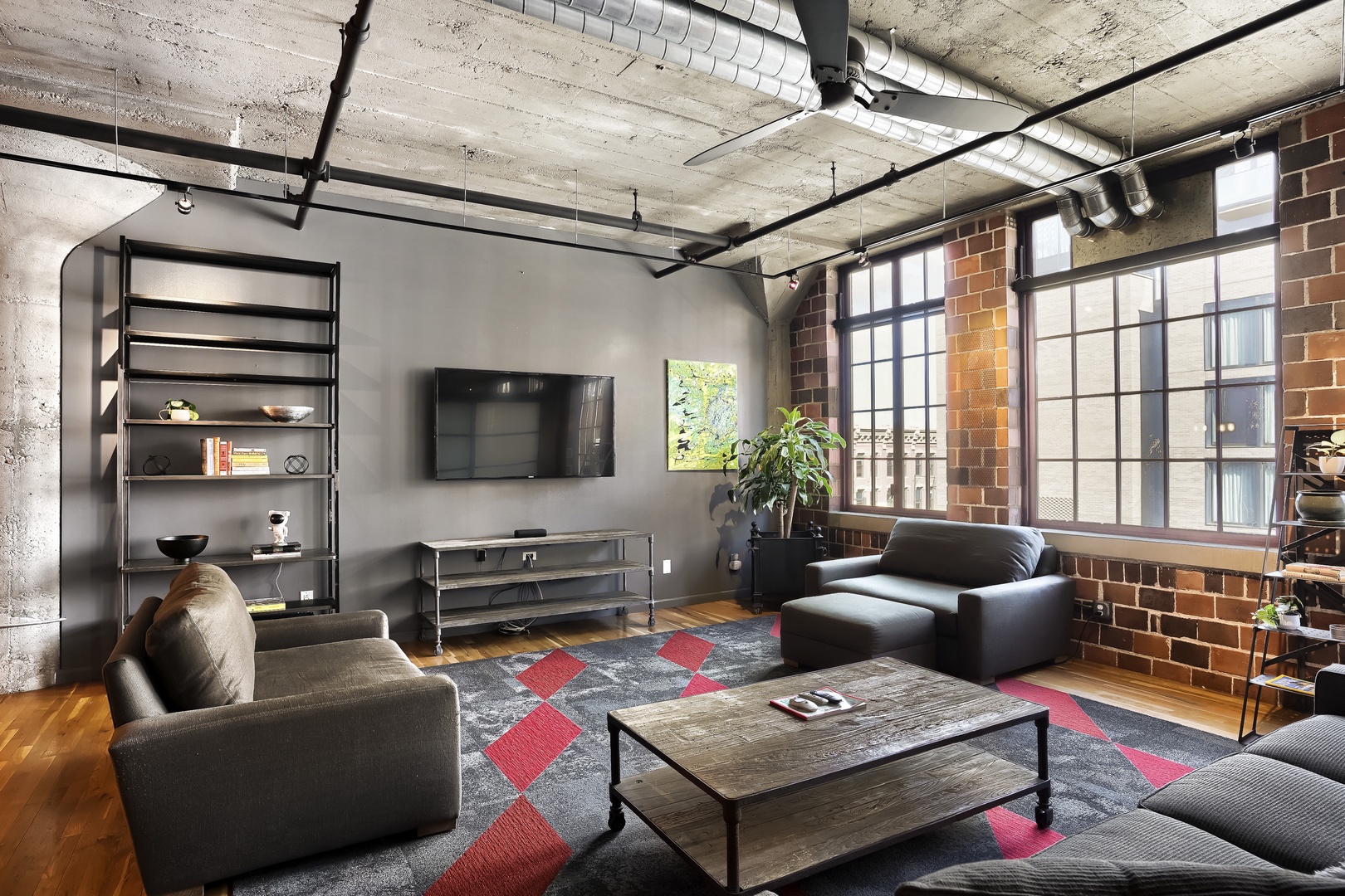 Unwind in this industrial-chic loft where exposed brick, soaring concrete ceilings, and oversized windows create your perfect urban retreat. Sink into the plush seating and let natural light fill your day.