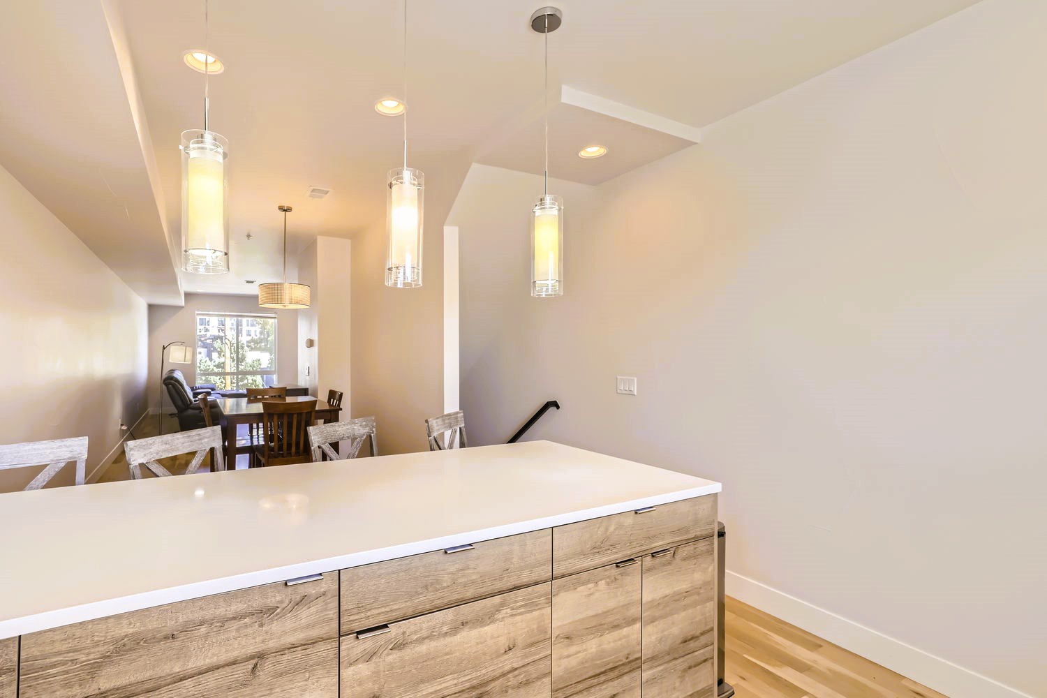 Your open-concept kitchen flows seamlessly into the dining area, where modern pendant lights illuminate shared meals and cherished conversations.