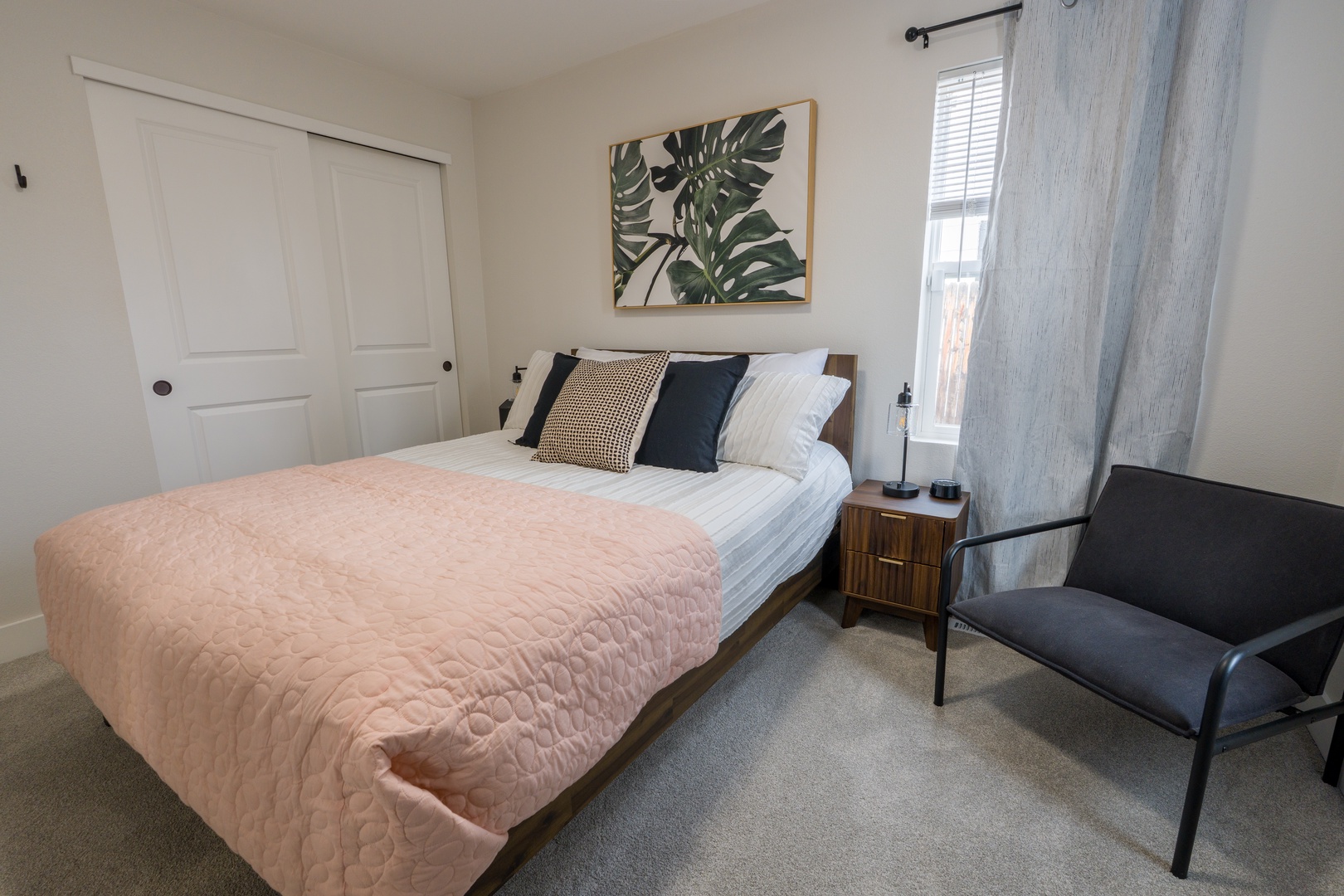 Drift off peacefully in this serene bedroom featuring a comfortable bed with soft linens, stylish decor, and natural light.