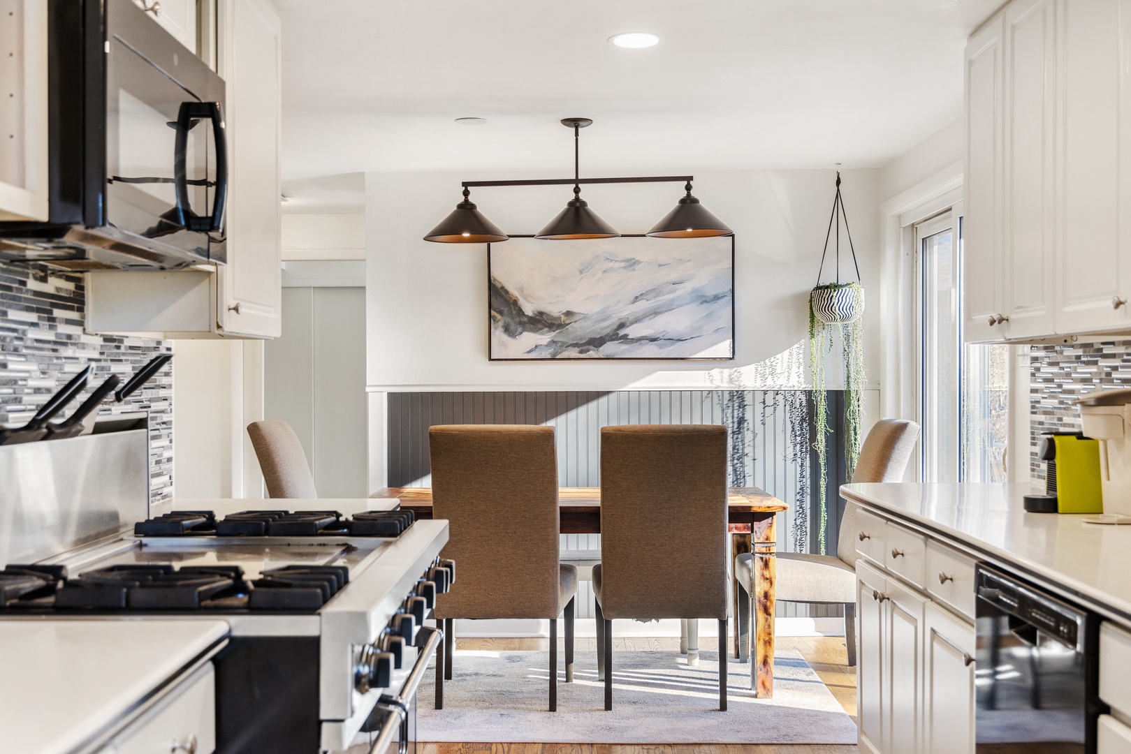 Your bright, open kitchen flows into an elegant dining space where shared meals become cherished memories beneath stylish pendant lighting.