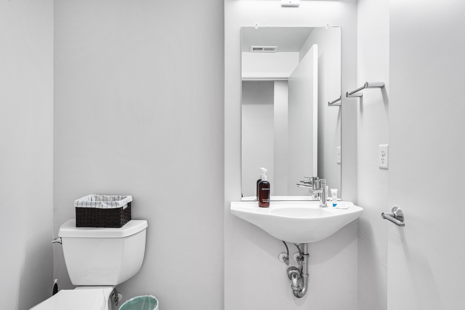Your private bathroom features a clean modern sink, mirror, and toilet, with thoughtful touches like fresh towels and amenities ready for your stay.