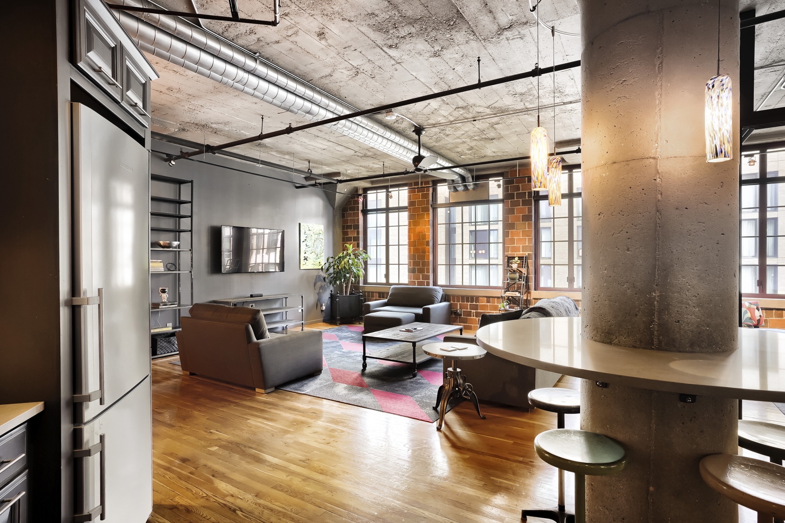 Step into your stunning open loft with soaring concrete ceilings, exposed brick, and warm hardwood floors. Unwind in the spacious living area where industrial charm meets modern comfort.