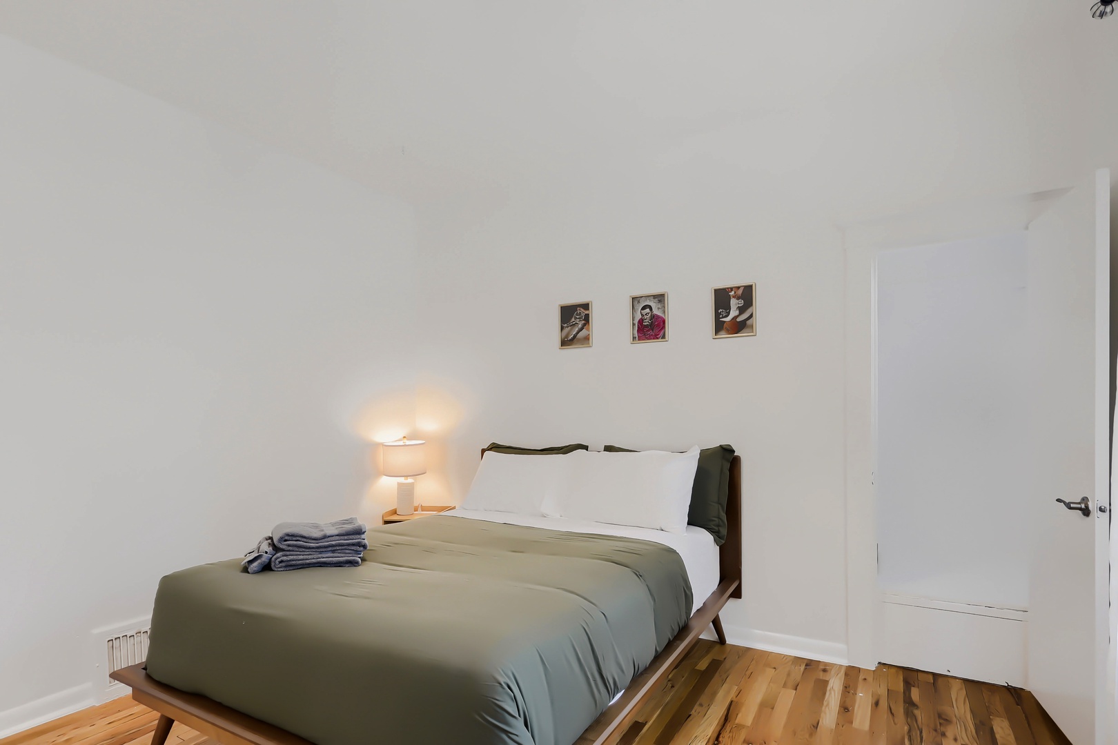 Unwind in this serene bedroom with a mid-century inspired bed, soft linens, warm lighting, and thoughtful touches to make your stay feel like home.
