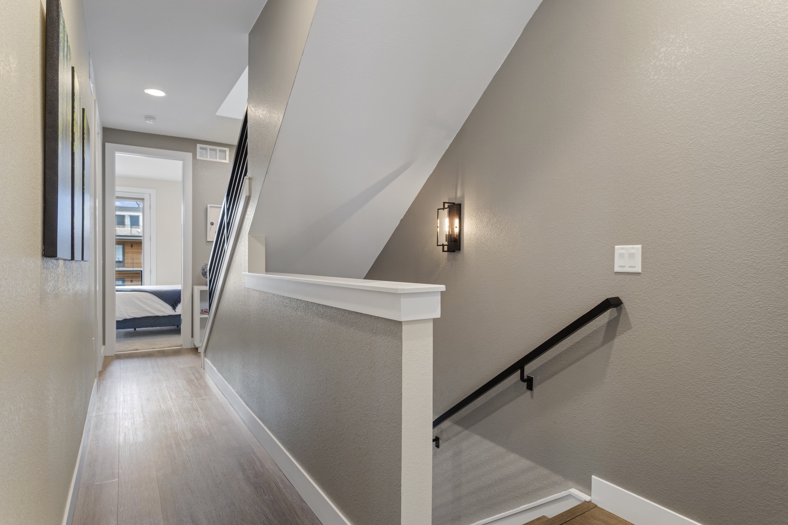 Navigate your stylish retreat with ease through this modern stairwell, where sleek railings and warm lighting guide you to comfort.