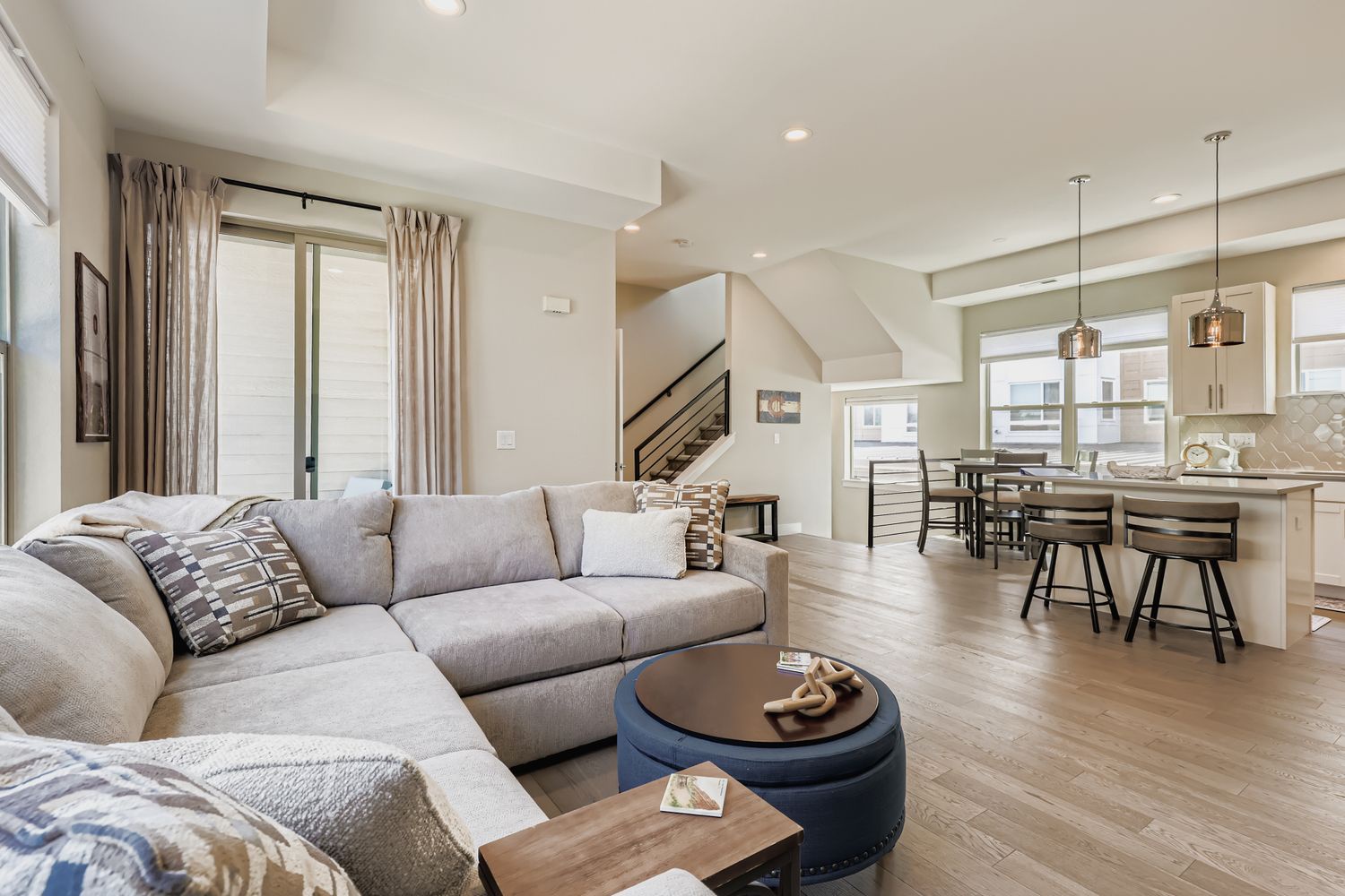 Sink into the plush sectional and let natural light fill your open-concept living space, where vaulted ceilings and modern finishes create an airy retreat perfect for relaxing or gathering with loved ones.