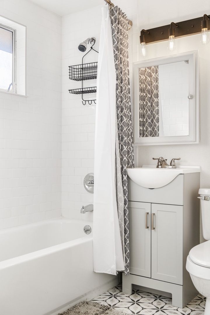 Freshen up in your stylish bathroom featuring a relaxing tub-shower combo and modern vanity—perfect for unwinding after exploring.