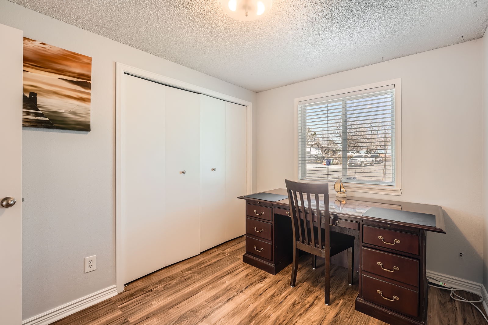 Your dedicated workspace awaits with rich wooden floors, elegant desk setup, and natural light streaming through your window blinds for productive mornings.