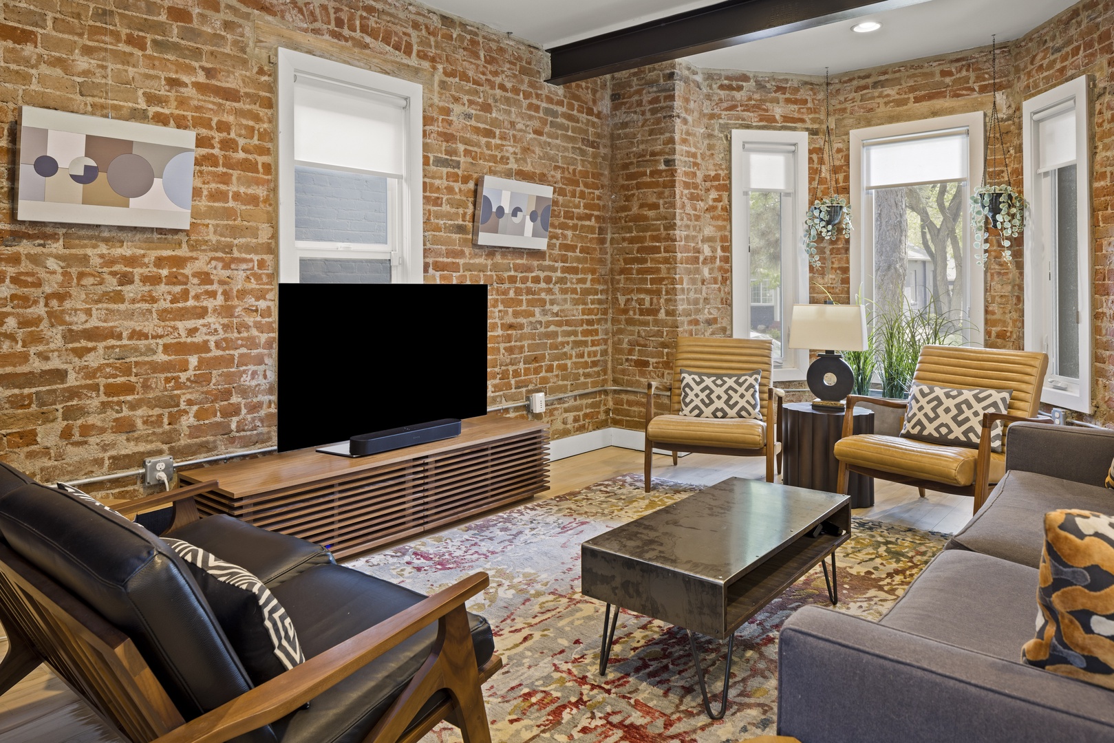 Sink into plush seating surrounded by warm exposed brick walls, where modern comfort meets timeless charm in your stylish retreat.