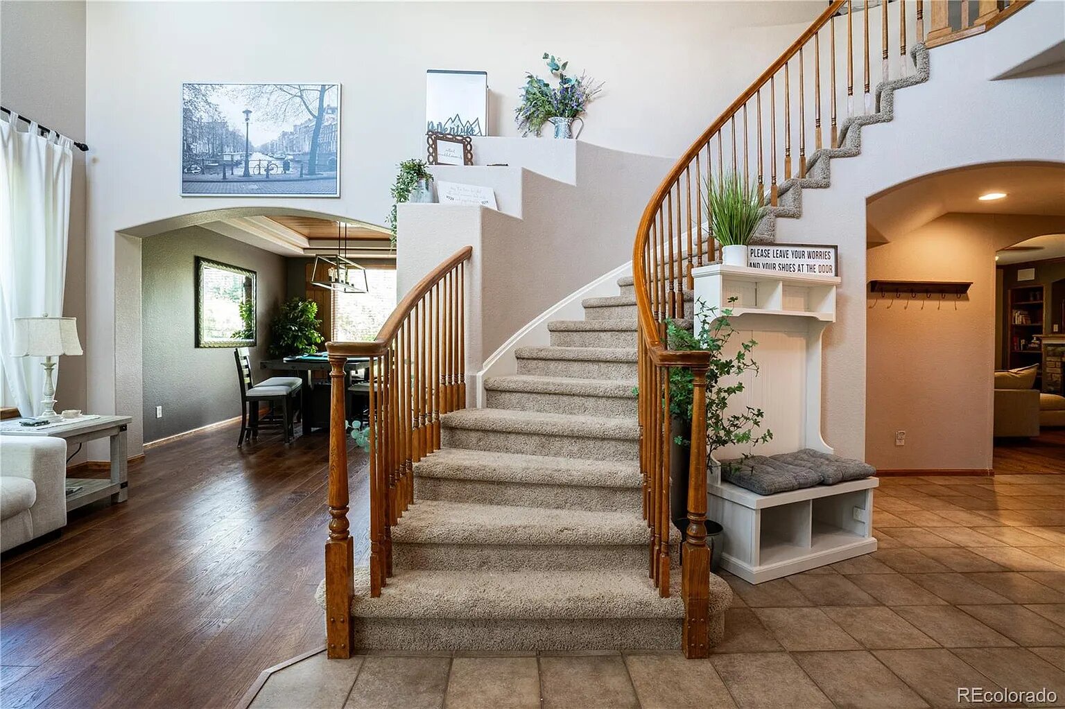 Step into this welcoming foyer where elegant curved stairs and open-concept living create the perfect backdrop for your memorable stay.