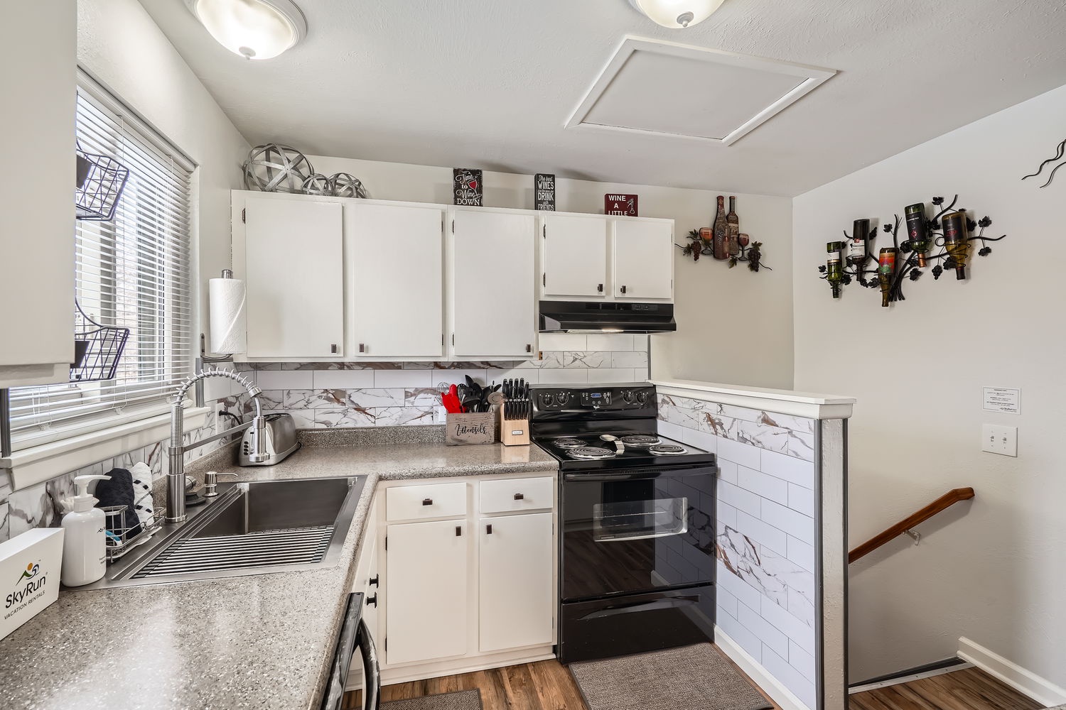 Your fully equipped kitchen features white cabinetry, marble-look countertops, and all the essentials for preparing your favorite meals during your stay.